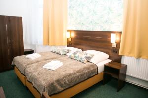 a bedroom with a bed with two towels on it at Hotel Polonia - Frankfurt/Oder in Frankfurt/Oder
