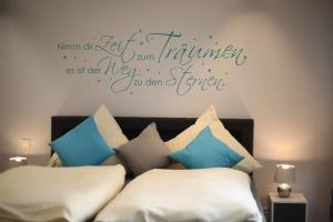 a bedroom with a bed with blue and white pillows at Komfort Appartements am Marktplatz in Bexbach