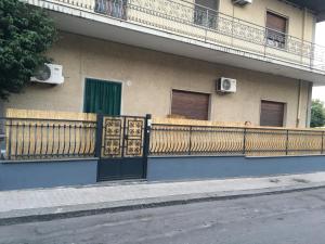 a building with a fence and a balcony at Limone & Girasole in Fiumefreddo di Sicilia