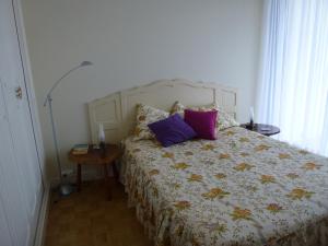 una camera da letto con un letto con cuscini viola di Résidence Rose Mousse ad Arcachon