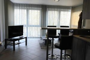 a living room with a kitchen with a bar and chairs at Komfort Appartements am Marktplatz in Bexbach