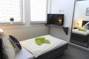 a room with a bed with a green bow on it at Komfort Appartements am Marktplatz in Bexbach