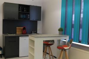 eine Küche mit einer Theke und Hockern in einem Zimmer in der Unterkunft Komfort Appartements am Marktplatz in Bexbach
