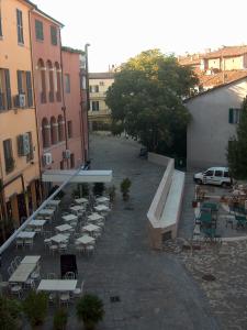 un cortile vuoto con sedie, tavoli e edifici di RESIDENZA LEON D'ORO a Cesena