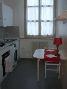 una cucina con tavolo e lavatrice di RESIDENZA LEON D'ORO a Cesena