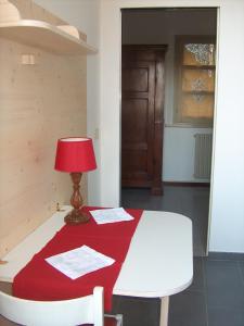 una stanza con un tavolo con una coperta rossa sopra di RESIDENZA LEON D'ORO a Cesena