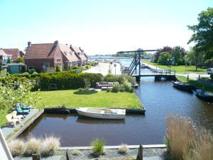 een boot is aangemeerd op een dok in een rivier bij Vakantie Studio Grou in Grou