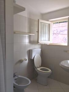 a white bathroom with a toilet and a sink at Capoliveri Punta Morcone M3 in Capoliveri