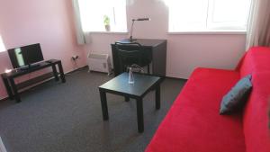 a living room with a red couch and a table at Hotel Šrejber in Červený Kostelec