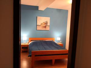 1 dormitorio con 1 cama con pared azul en Apartment Plavia Biograd en Biograd na Moru