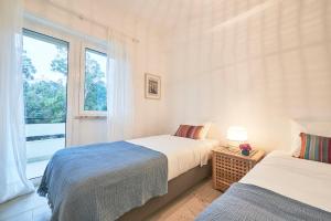 two beds in a room with a window at Light Apartment With Amazing Balcony, by TimeCooler in Lisbon
