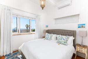 a white bedroom with a bed and a window at Villa on Camps Bay Drive in Cape Town +44 photos