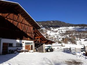 a building with snow on the ground next to a mountain at Ferienwohnung Lechthaler Andrea in Wenns
