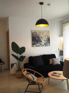 ein Wohnzimmer mit einem schwarzen Sofa und einem Tisch in der Unterkunft Los Boliches wifi 300 m playa beach in Fuengirola