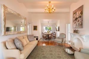 a living room with a couch and a mirror at Villa on Camps Bay Drive in Cape Town