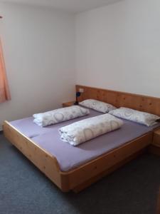 a bed in a room with two pillows on it at Ferienwohnung Lechthaler Andrea in Wenns