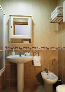 ein Badezimmer mit einem Waschbecken, einem Spiegel und einem WC in der Unterkunft Los Boliches wifi 300 m playa beach in Fuengirola