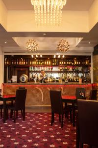 a restaurant with a bar with tables and chairs at Wessex Hotel in Street