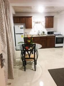 a kitchen with a table and a refrigerator at Calliandras Apartment Complex in Kingstown