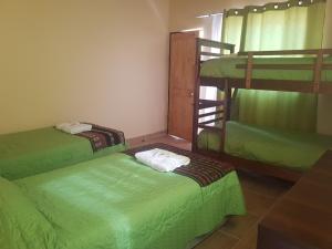 a room with three bunk beds in a room at Altos del Lascar in Toconao