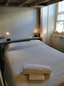 una camera da letto con un letto con uno sgabello per i piedi di Ca' antica a Rovereto
