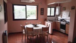 a kitchen with a table and chairs in a room at Chalets Andalgala in Merlo