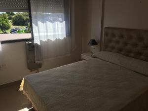 a bedroom with a large bed and a window at Sol y Arena Plaza in San Clemente del Tuyú