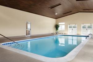 a large swimming pool with blue water in a building at Baymont by Wyndham Elizabethtown in Elizabethtown