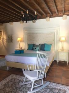 a bedroom with a bed and a white chair at Saint Artemios Hotel and Oriental Suites in Rhodes Town