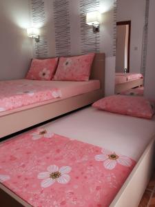 a bedroom with two beds with pink flowers on them at Apartments Taida in Dobra Voda