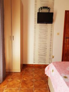 a bedroom with a tiled floor with a bed and a television at Apartments Taida in Dobra Voda