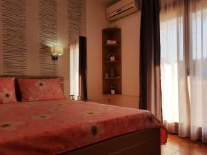 1 dormitorio con 1 cama con manta roja y ventana en Apartments Taida en Dobra Voda