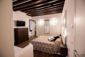 sypialnia z łóżkiem i telewizorem w obiekcie Silver Suite w Wenecji