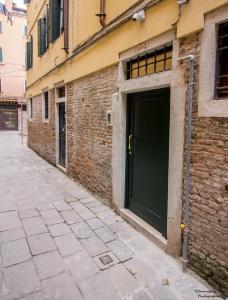 zielone drzwi na boku budynku ceglanego w obiekcie Silver Suite w Wenecji