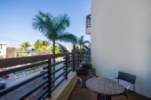 a balcony with a table and chairs and palm trees at La Divina by Aldea Thai in Playa del Carmen