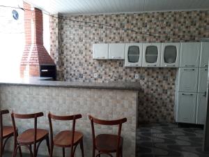 un bar con cuatro taburetes en una cocina en Residencial Lage, en Porto Seguro