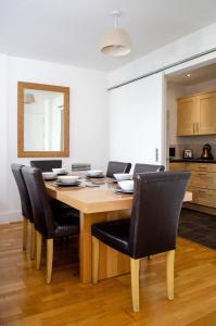 a dining room with a wooden table and black chairs at Serviced Apartment In Liverpool City Centre - Free Parking - Balcony - by Happy Days in Liverpool