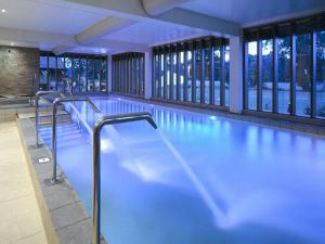 a swimming pool with blue water in a building at New Park Manor Hotel - A Luxury Family Hotel in Brockenhurst