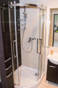 a shower with a glass door in a bathroom at ApartamentyPrzyMorzu Classic Kołobrzeg in Kołobrzeg