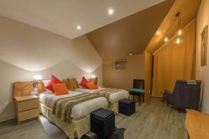 Habitación de hotel con cama con almohadas de color naranja en Casa Mir en Saint-Lary-Soulan