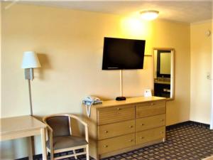 a hotel room with a dresser with a television on it at Budget Inn Conway in Conway