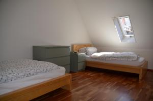 1 dormitorio con 2 camas, vestidor y ventana en Mendlers Ferienwohnung, en Wangen im Allgäu
