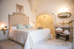 - une chambre avec un grand lit et un miroir dans l'établissement Relais l’Antico Pozzo, à Martina Franca