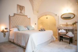 a bedroom with a large bed and a mirror at Relais l’Antico Pozzo in Martina Franca +44 photos