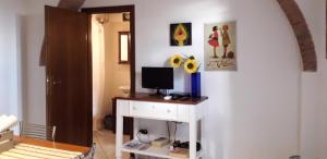 a room with a desk with a computer on it at Happy Flat in Riparbella