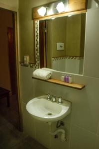 a bathroom with a sink and a mirror at Hostal El Korú in San Carlos de Bariloche