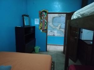 1 dormitorio con cama y pared azul en Cliff's Hostel, en La Gruta