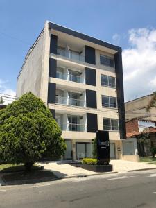 un gran edificio con un árbol delante en Hotel CSI Medellín, en Medellín