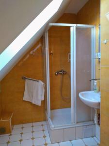 La salle de bains mansardée est pourvue d'une douche et d'un lavabo. dans l'établissement Vilka Tkáč, à Kvačany