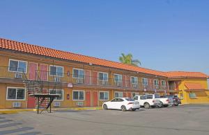 a large building with cars parked in a parking lot at Del Mar Motel in Rosemead